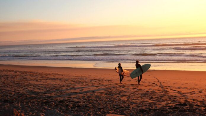 Surfistas preparándose para las olas de la mañana cerca de la playa Fishtral